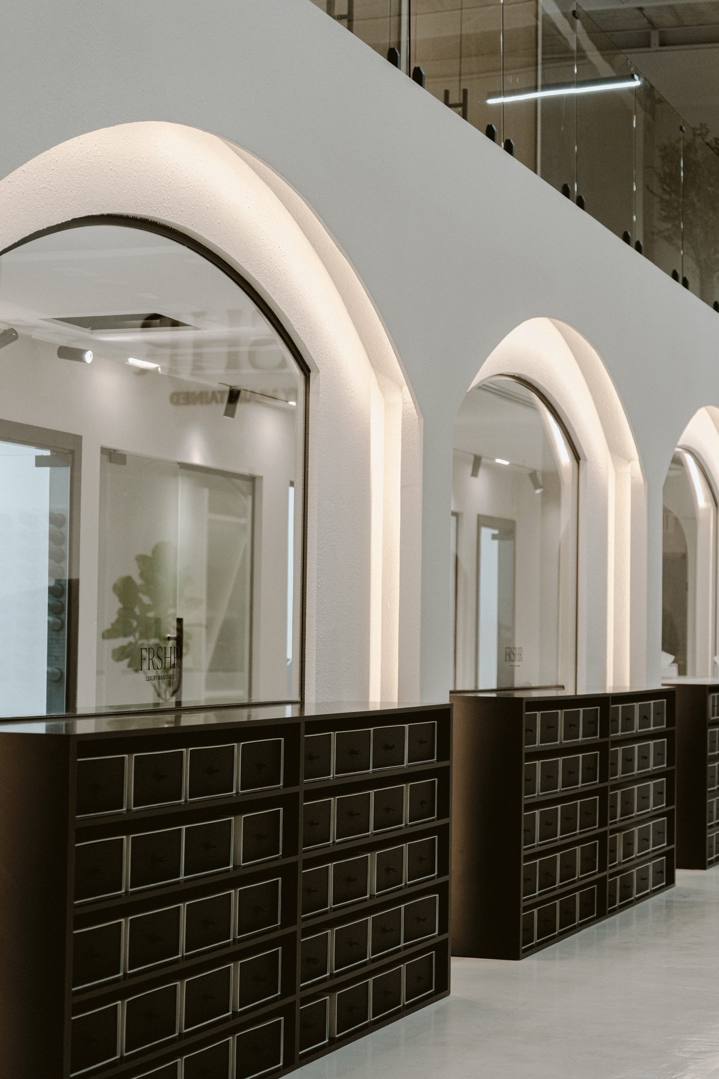 The arched shelving of the FRSHR workshop, stacked with black boxes