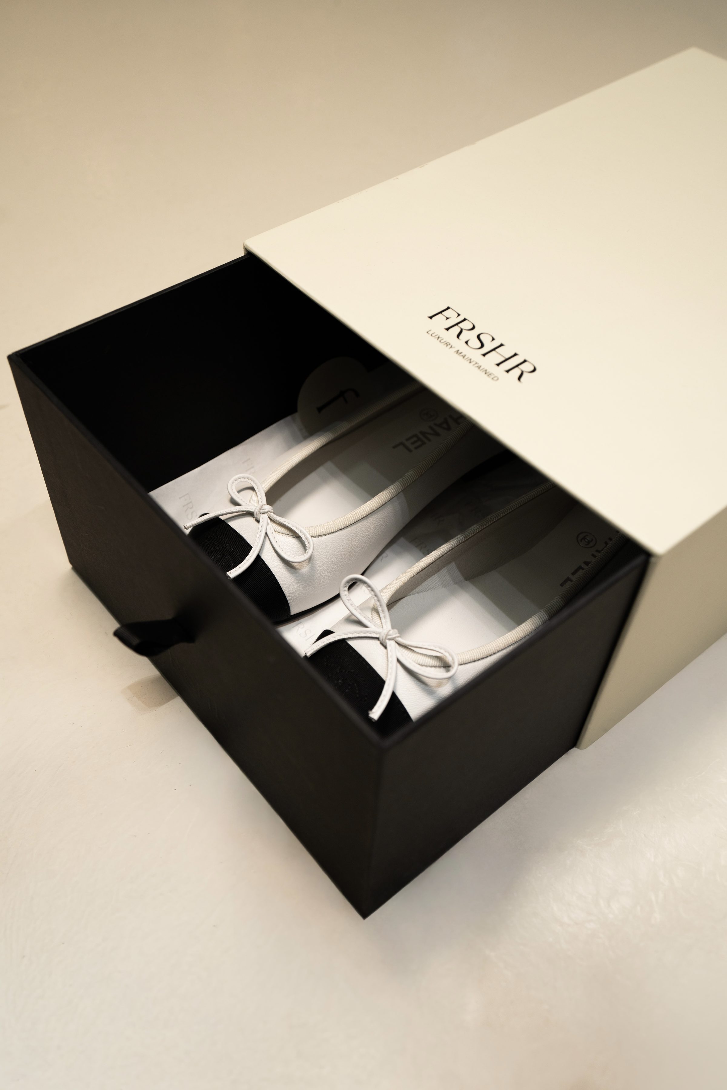 A pair of Chanel flats packed in a FRSHR box